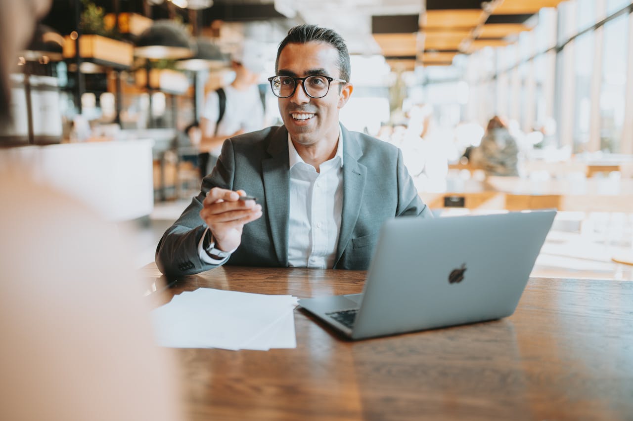 Smiling Man in Suit with MacBook